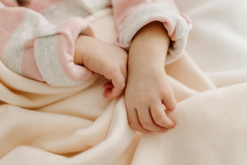 A baby's hand is on a blanket