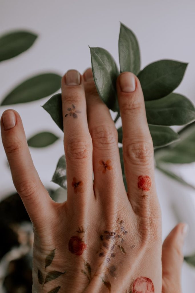 Person's Left Hand Touching Green Leaves